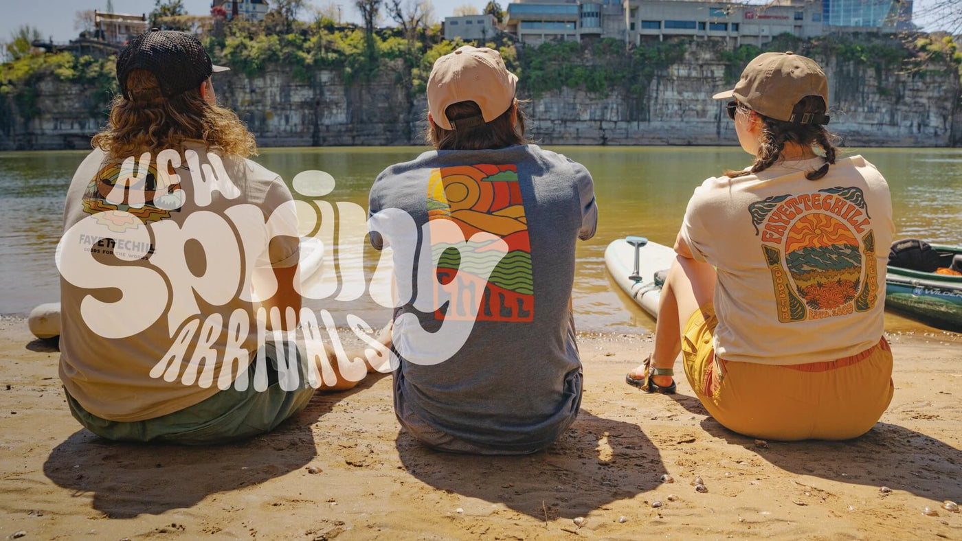 Photo of three people seating on lake short in Fayetteville t shirts